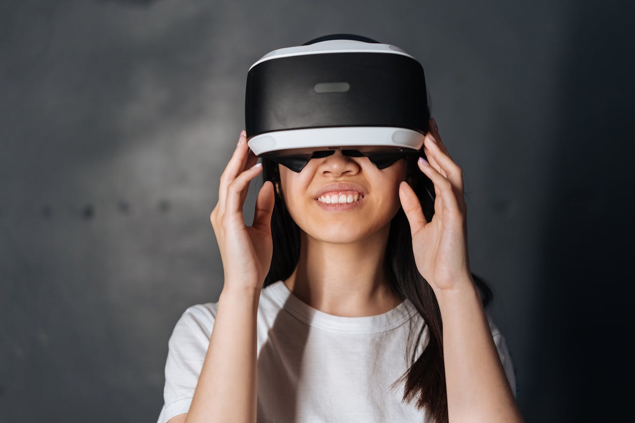 Smiling young woman immersed in virtual reality, wearing VR headset indoors.